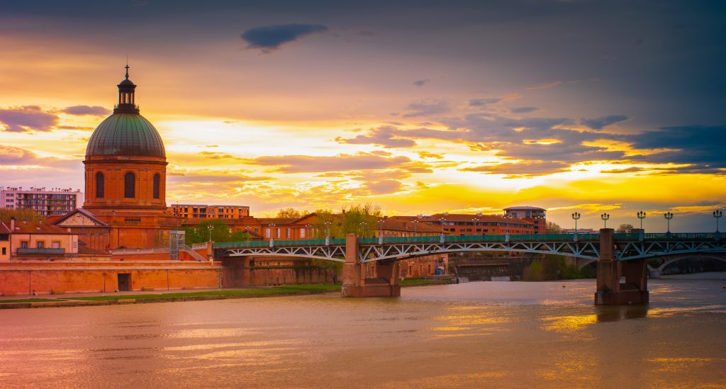 The dome of the Hopital de la Grave at dusk over the Garonne River in Toulouse