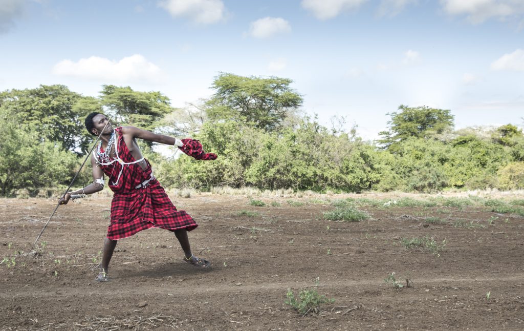 handsome maasai warrior throwing his spear