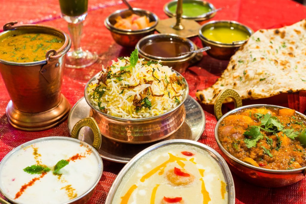 Indian chicken curries with naan bread, rice and pickles.