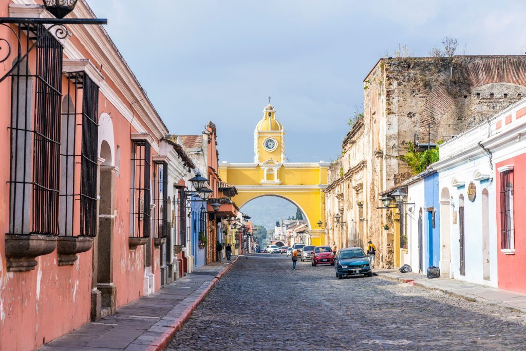 Rue pavée menant à l'Arche de Santa Catalina, entourée de maisons coloniales colorées dans le centre historique d'Antigua. Antigua Guatemala, Guatemala.