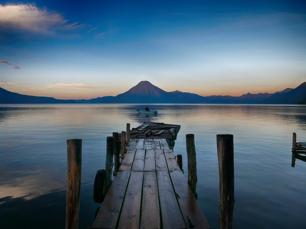 Ponton en bois s'avançant sur le lac Atitlán avec le volcan San Pedro en arrière-plan au coucher du soleil. Sololá, Guatemala.